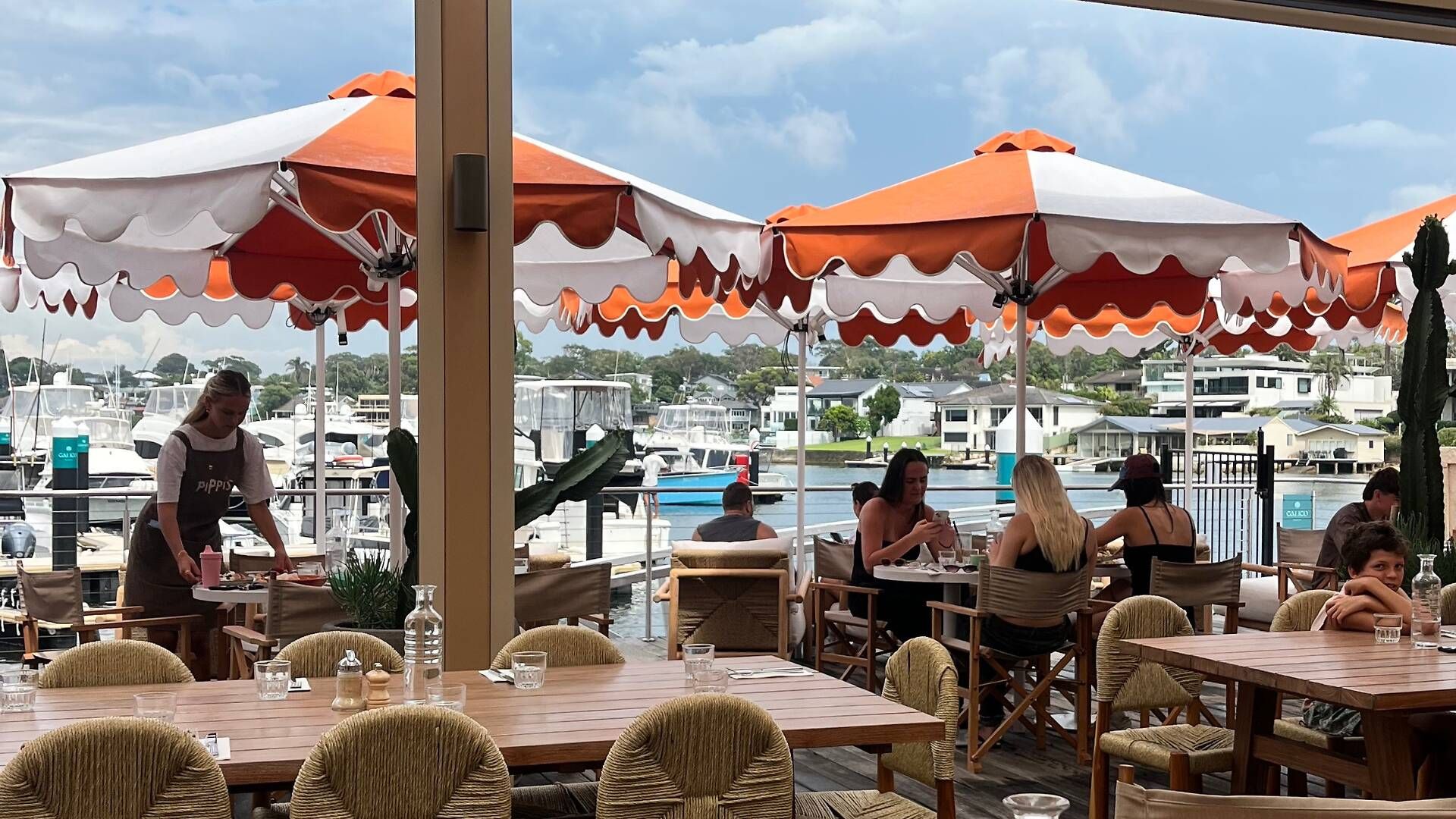 Long tables under the umbrellas at Pippis Cronulla, the marina behind