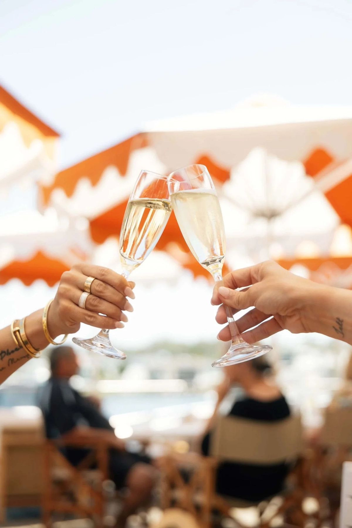 Two glasses of bubbles raised under the umbrellas